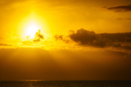 Sunrise over the sea. Bright sun under the water surface. Sun up above horizon. Morning seascape.