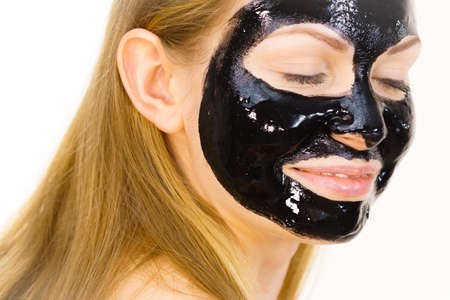 Young woman with cosmetic on face, carbo detox black peel off mask. Spa treatment. Skincare.の写真素材