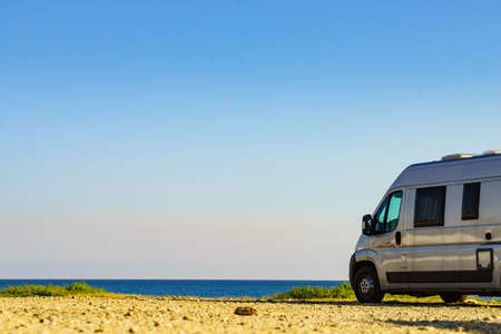 Camper rv van on mediterranean coast in Spain. Wild camping on beach. Holidays and travel in motor home.の写真素材