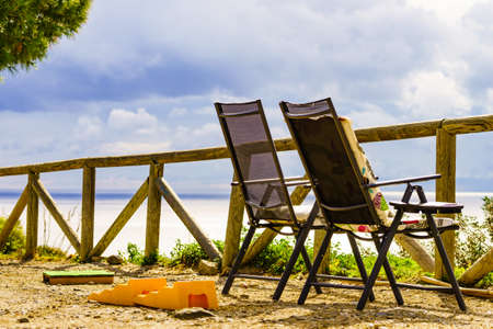 Two empty folding camp chairs outdoor on beach sea shore .. Holidays relaxation on trip.の写真素材