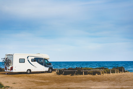 Camper, recreational vehicle on mediterranean coast in Spain. Camping on nature beach. Holidays and travel in motor home.の写真素材