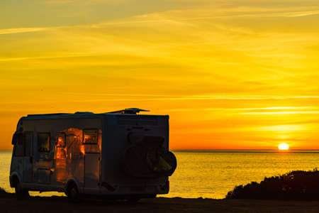 Camper rv at sunrise on mediterranean coast Costa del Sol, Andalucia Spain. Camping on nature beach. Vacation and trip in motor home.の写真素材
