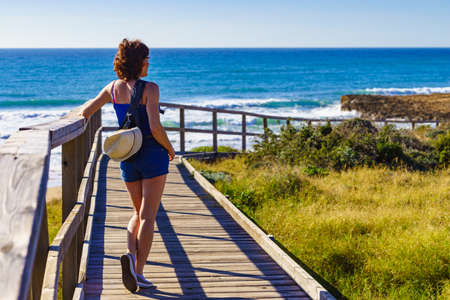 Tourist woman walking relaxing on beach seashore, enjoying sunlight. Cala Magre in Calblanque Regional Park, Murcia region Spain.の写真素材