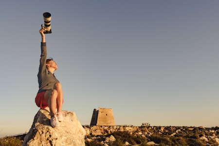 Female tourist with camera taking travel photo from Mesa Roldan watchtower, Cabo de Gata Nijar Natural Park in Almeria province, Andalusia Spain.の写真素材