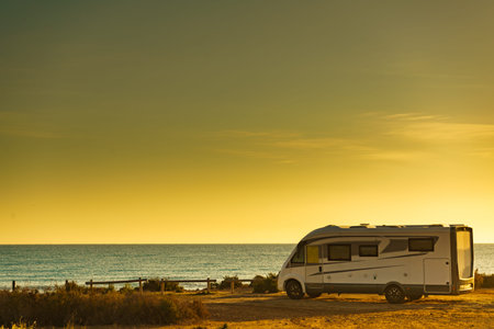 Camper, recreational vehicle on mediterranean coast in Spain. Camping on nature beach. Holidays and...