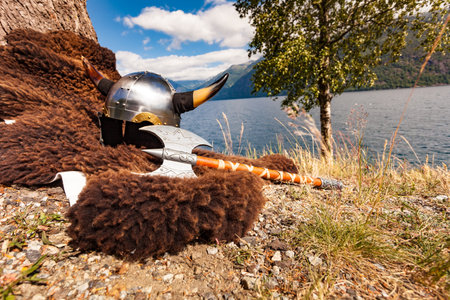 Viking helmet with weapons on fjord shore in Norway. Tourism and traveling concept