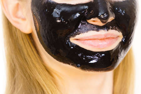 Young woman with cosmetic on face, carbo detox black peel off mask. Spa treatment. Skincare.の写真素材