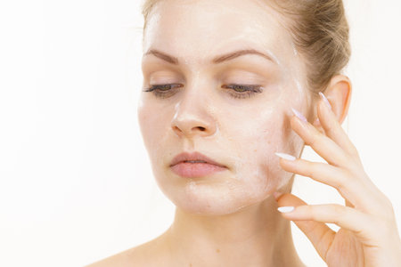 Young woman with cream cosmetic, mask moisture on her face. Beauty treatment. Skincare.の写真素材