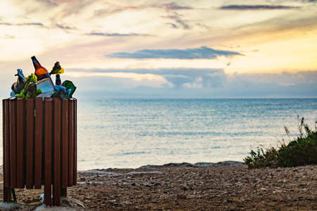 Seaside landscape. Spanish sea shore with garbage bin full of trash. Keeping the beach clean.の写真素材