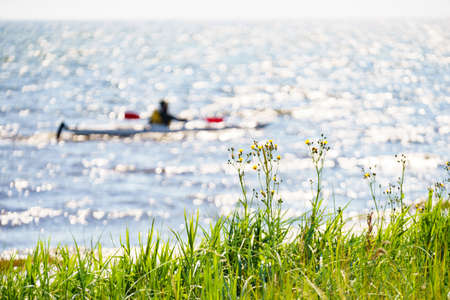 Water lake shore and person kayaking in the backgroundの写真素材