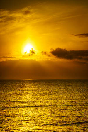 Sunrise over sea. Bright sun under the water surface. Sun up above horizon. Morning seascape.の写真素材