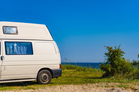 Camper van camping on sea shore in summer. Traveling by motor home. Caravan vacation.の写真素材