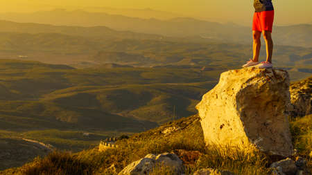 Tourist woman legs on rock viewpoint enjoying sunset landscape. Mesa Roldan location in province Almeria, Andalusia Spain. Cabo de Gata Natural Park.の写真素材