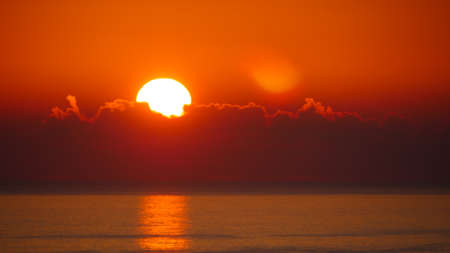 Sunrise over sea. Bright sun under the water surface. Sun up above horizon. Morning seascape.の写真素材