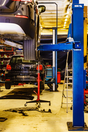 Car in service. Auto raised on lift in autoservice.