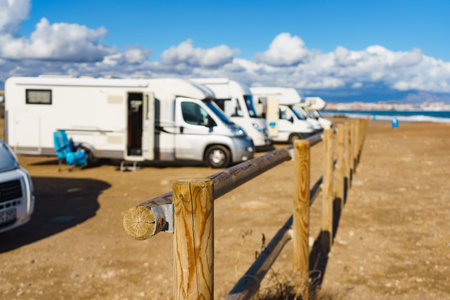 Beach woden fence and caravan camping on mediterranean coast, Alicante city in the distance, Costa...