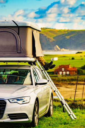 Car with roof top tent camping on Asturias coast in Spain. Holidays and traveling.