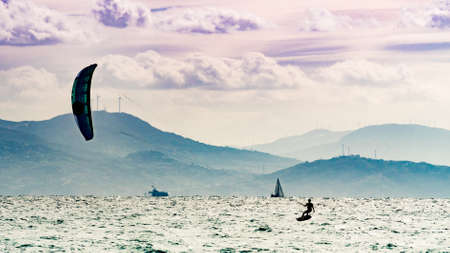 Kiteboarding. Kite surfer rides waves, Tarifa, Cadiz in Spain. Sports activity. Kitesurfing action.の写真素材