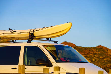 Car van with canoe on top roof against sky. Active lifestyle sports concept.の写真素材