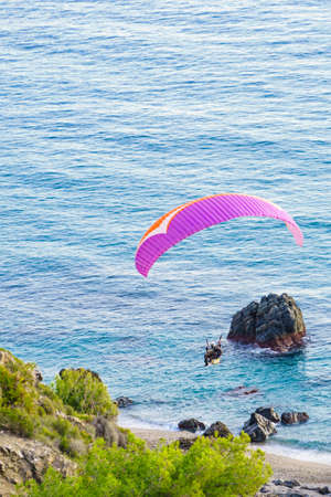 Paraglider flying over beach sea shore. Paragliding. Extreme sport.の写真素材