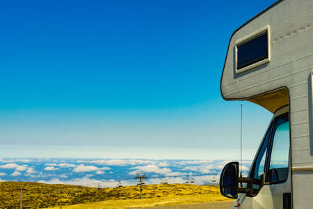 Caravan camping in mountains above clouds. Torre mountain peak of Serra da Estrela in Portugal. Adventure and holidays with mobile home.の写真素材