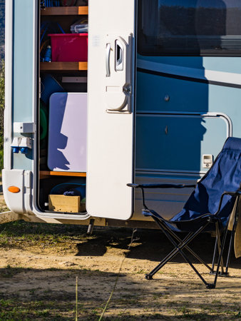 Camper rv with open storage box camping on nature. Adventure with motor home.