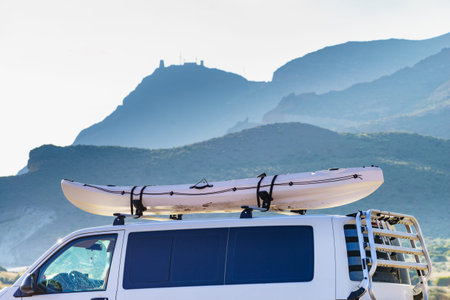 Car van with canoe on top roof against mountain nature. Cabo de Gata Nijar Natural Park, province...