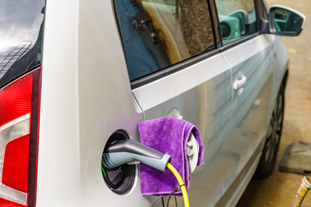 Electric car at charging station with power outlet. Ecological transportation. Automotive technology concept.の写真素材