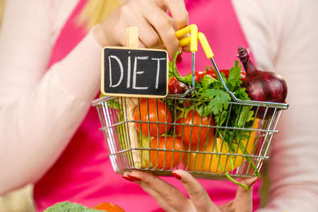 Shopping basket with diet sign and many colorful vegetables. Healthy eating lifestyle, vegetarian food.の写真素材
