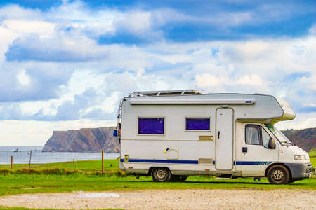 Camper camping on beach at Asturias coast in northern Spain. Cape Penas cliff in the distance. Travel with motor home.の写真素材