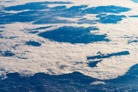 View from airplane to clouds and land. Aircraft flying over Norway Scandinavia.の写真素材