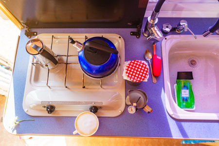 Caravan rv inside, kitchen area. Preparing coffee in moka pot on stove. Holidays, adventure with motor home. Van life lifestyle.の写真素材