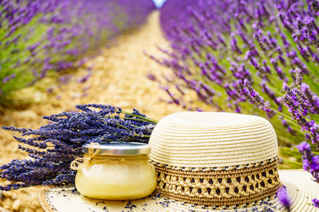 Summer hat and glass with honey against fresh lavender field background. Attraction trip for french vacation in Provence.の写真素材