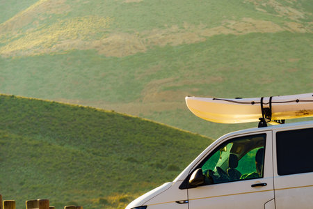 Car van with canoe on top roof against mountain nature. Active lifestyle sports concept.の写真素材