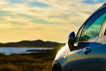 Auto parking on seashore in sunset time. Rear view mirror closed for safety at car park.の写真素材