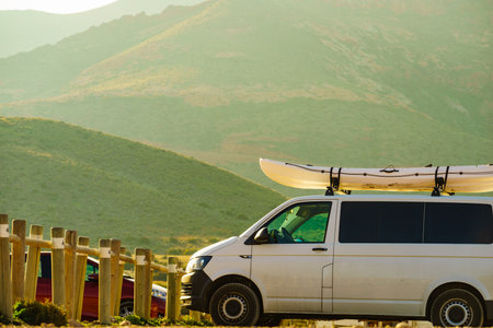 Car van with canoe on top roof against mountain nature. Active lifestyle sports concept.の写真素材