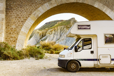 Caravan in Tabernas desert camping near road arch bridge, Almeria Spain. Traveling with motorhome.の写真素材
