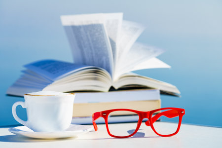 Reading on holiday. Coffee cup, book and red glasses against blue sea water. Relaxation on holidays trip. Mental health break.の写真素材