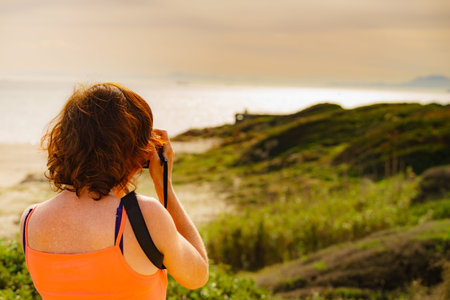 Tourist mature woman take travel picture from seaside landscape in Spain.