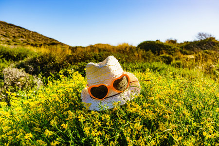 Summer hat on yellow flowers, mediterranean sea coast landscape in Spain. Hiking, camping, active...