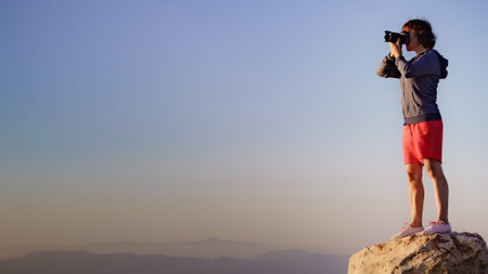 Tourist woman with camera taking travel photo from good viewpointの写真素材