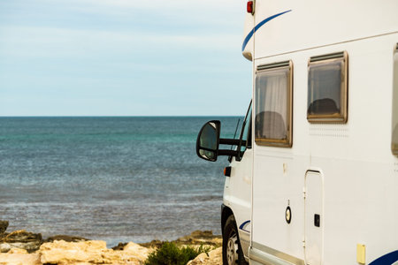 Camping on sea shore. Camper vehicle on beach, mediterranean coast in Spain.の写真素材
