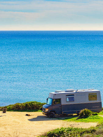 Camper rv caravan on mediterranean coast in Spain. Wild camping on sea shore. Holidays trip with motor home.の写真素材