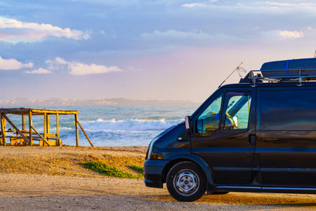 Camper van recreational vehicle at sunrise on mediterranean coast in Spain. Camping on the beach. Vacation and traveling in motor home.の写真素材