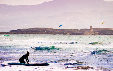 Female learning how to surfing, practicing paddling and standing up on surfboard. Water sport...