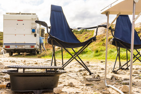 Empty portable barbeque grill and camping equipment Rv caravan in the background.の写真素材