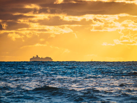 Sunset seascape with cargo container industrial ship on horizon. Logistic shipping concept.の写真素材