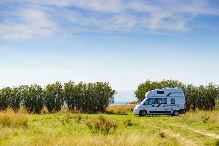 Camper van wild camping on nature in summer. Travel by motor home. Caravan vacation.の写真素材