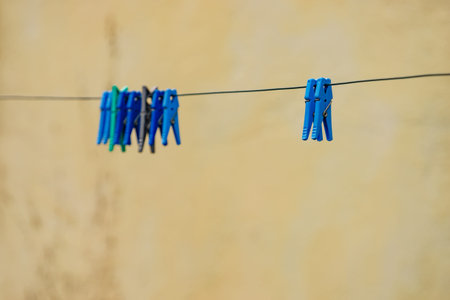 Clips for washing laundry clothes pegs on string rope outdoor. Housework concept