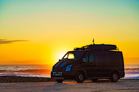 Camper van recreational vehicle at sunrise on mediterranean coast in Spain. Camping on the beach....